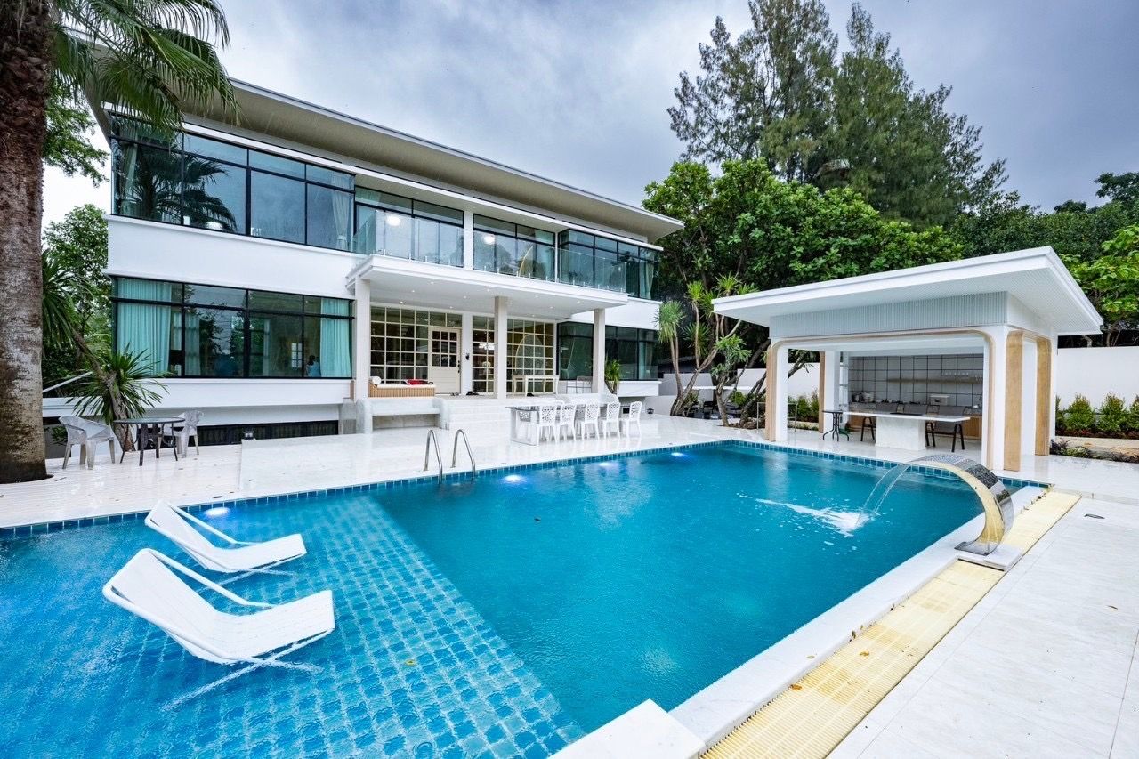 The Valley Khao Yai II pool villa with waterfall feature and swim-up bar. Loungers sit in the pool.