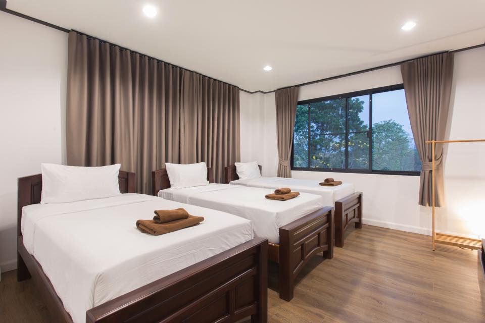 The Valley Khaoyai V Villa bedroom with three single beds and brown accents in Khao Yai, Thailand.