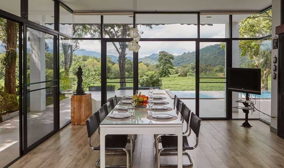 Dining room at The Valley Khaoyai pool villa with glass table and mountain view in หมูสี เขาใหญ่.