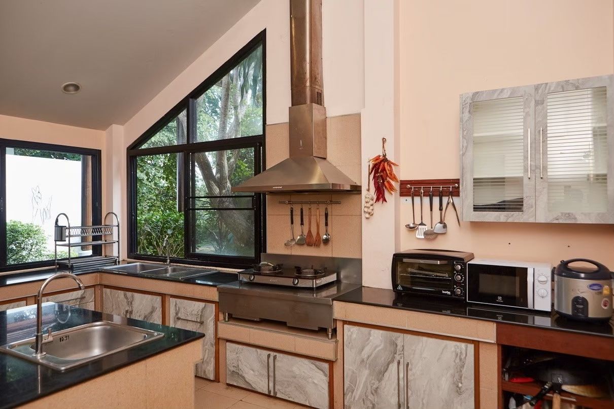 Kitchen with marble countertops, stove, and appliances at The Valley Khaoyai I pool villa, หมูสี เขาใหญ่.