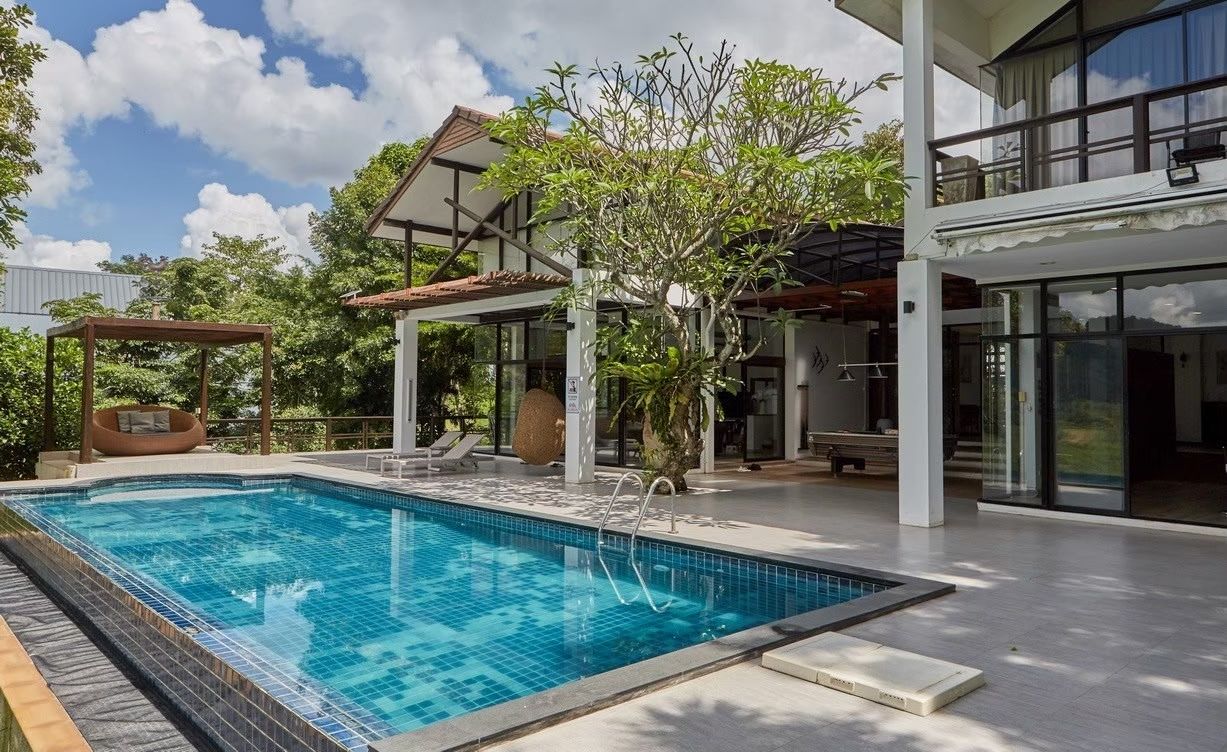 The Valley Khaoyai I pool villa. View of the pool, lounge chairs, and outdoor seating area in หมูสี เขาใหญ่.