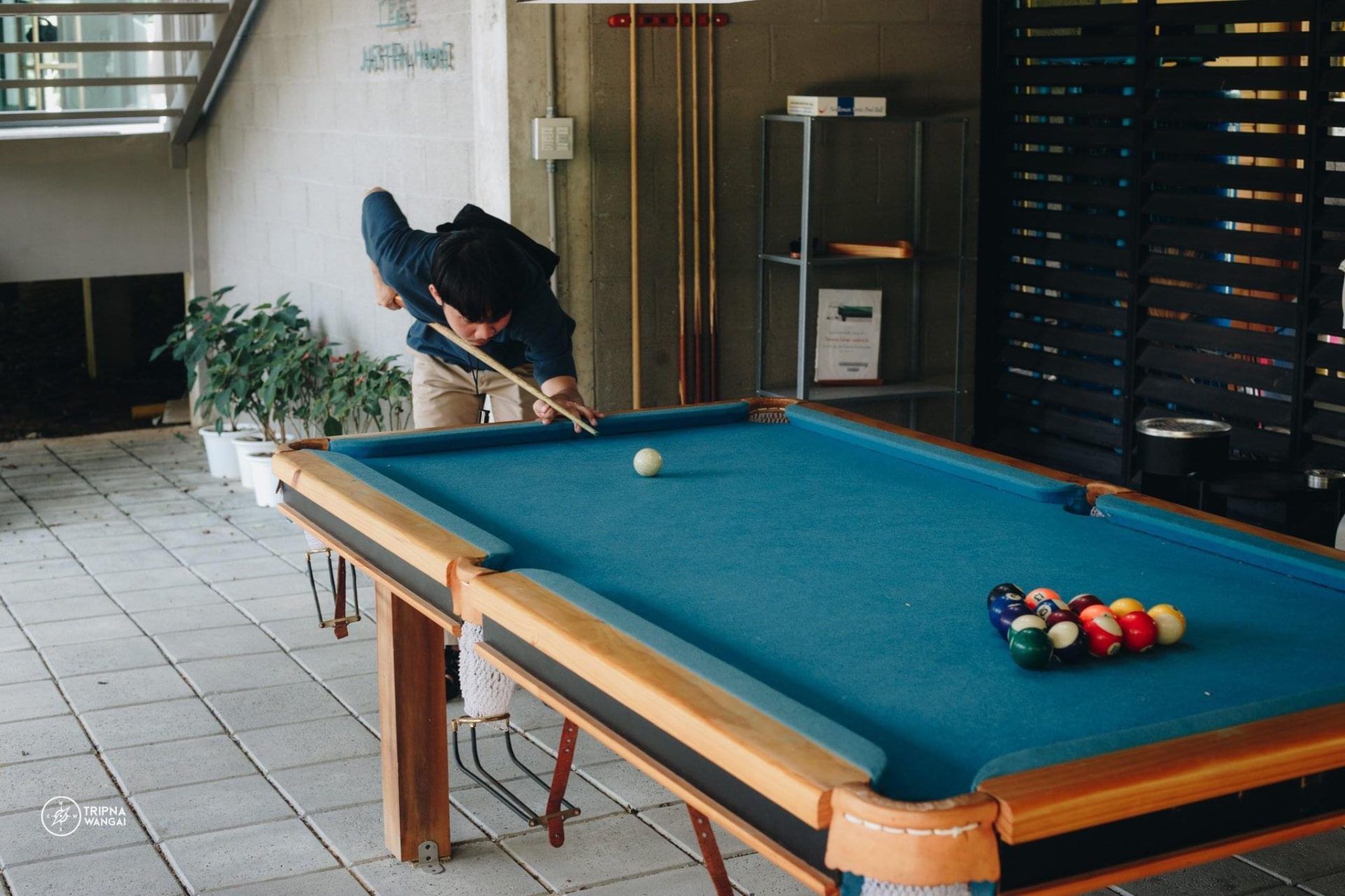 Man playing pool at The Valley Khaoyai VI Villa. Billiard balls racked on blue felt. Indoor entertainment at this pool villa.