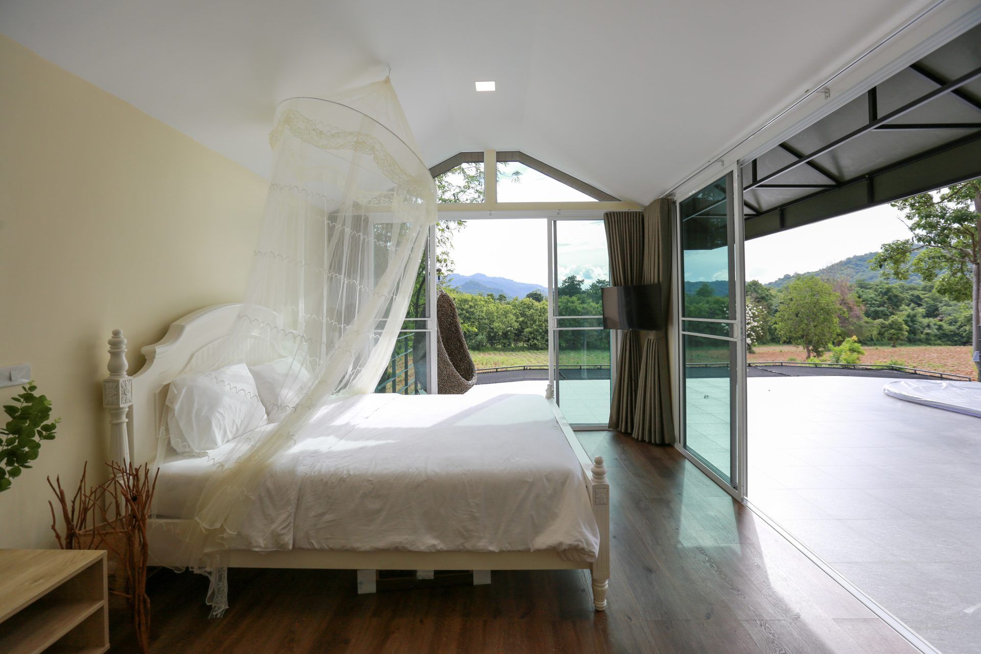 Bedroom with mosquito net and mountain view at Tree House III Pool Villa, Khao Yai. Relax in nature, 10 minutes from the park