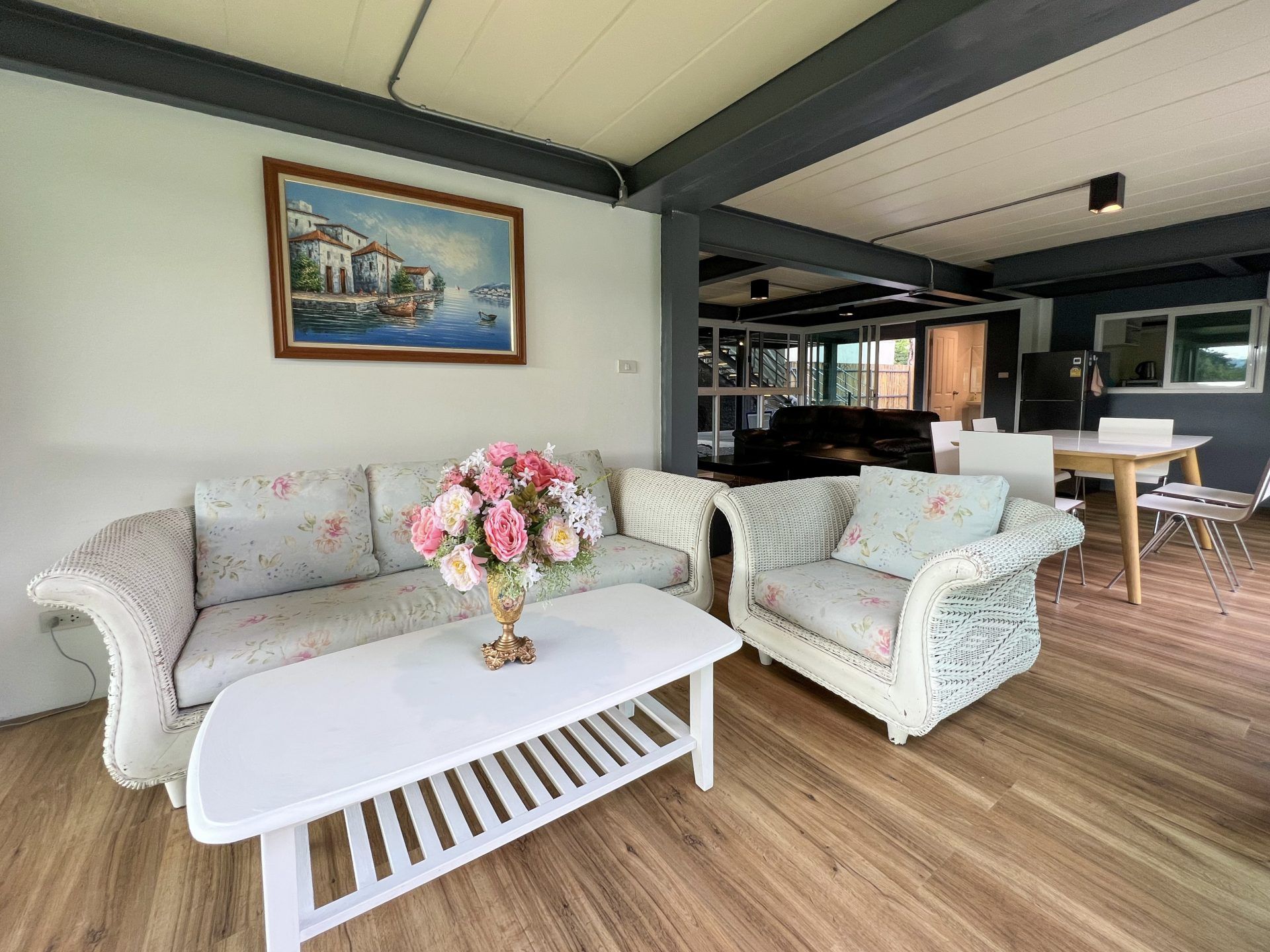 Living area with floral sofa and white wicker chair at Tree House III Pool Villa, เขาใหญ่. Relax in style.