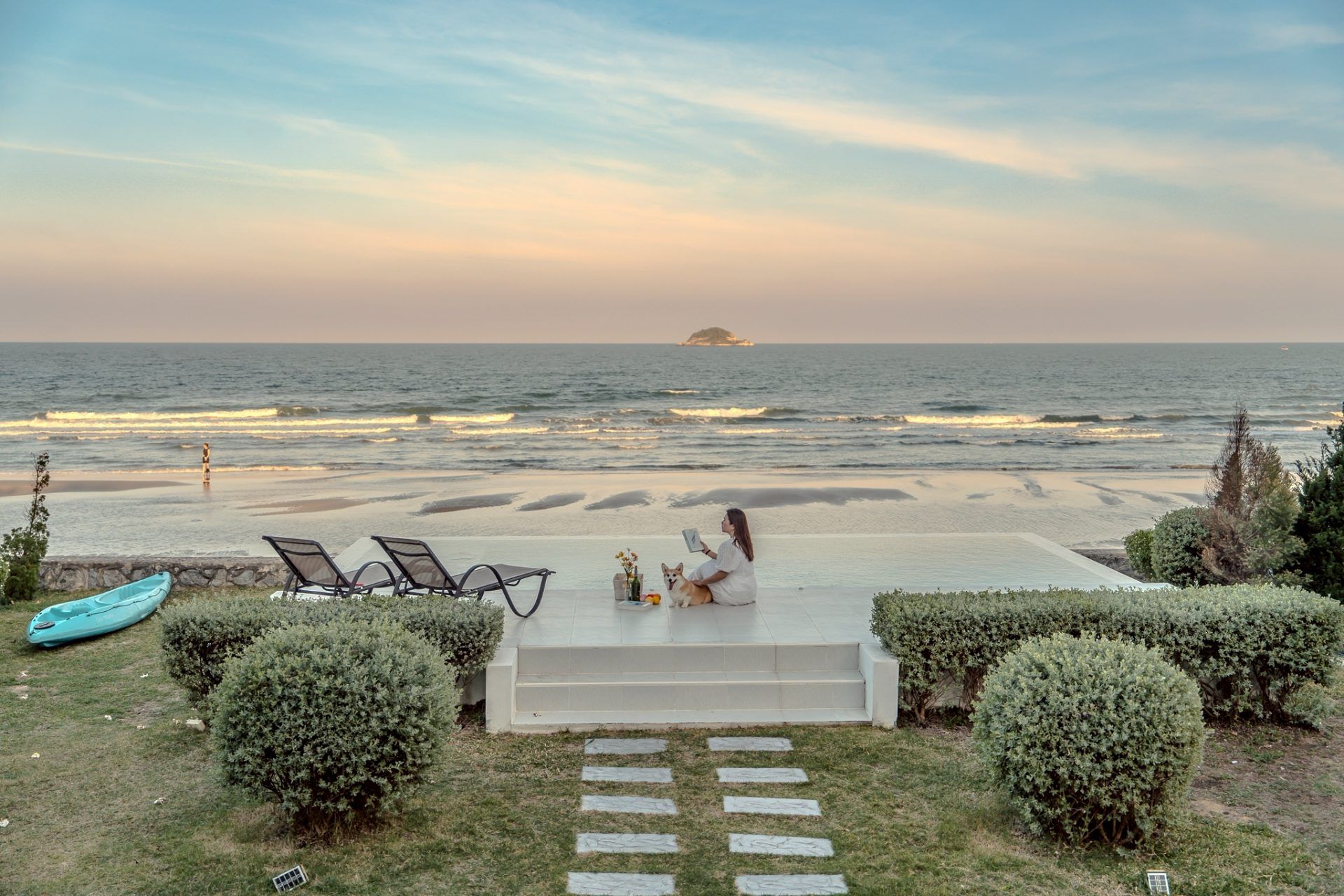 Woman and dog relax on the beachfront terrace at Twenty-Six Pool Villa Hua-hin, หัวหิน 101 ประจวบฯ. Ocean view.