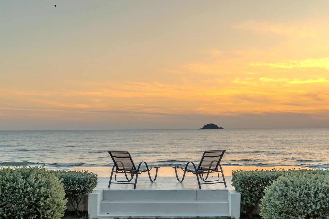 Ocean view from Twenty-Six Pool Villa Hua-hin, หัวหิน 101 ประจวบฯ. Two chairs face the sea at sunset.