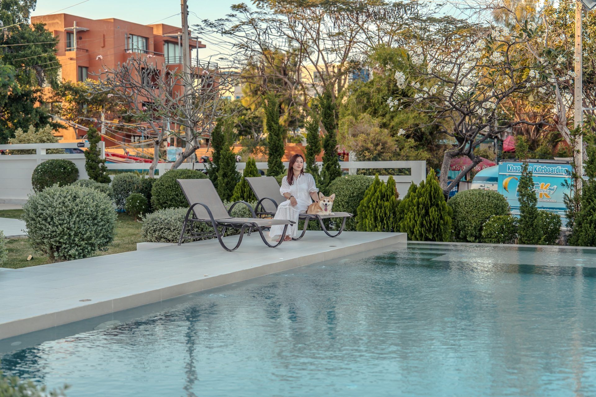 Woman and dog relax on lounge chairs by the pool at Twenty-Six Pool Villa Hua-hin, หัวหิน 101 ประจวบฯ.