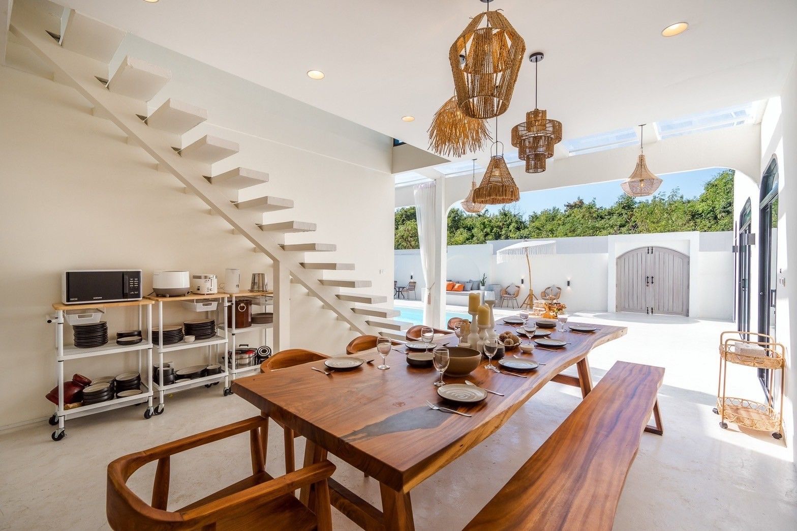 Dining area at White Coco V Pool Villa, พัทยากลาง-นาเกลือ. Large wooden table set for a meal, with pool view.