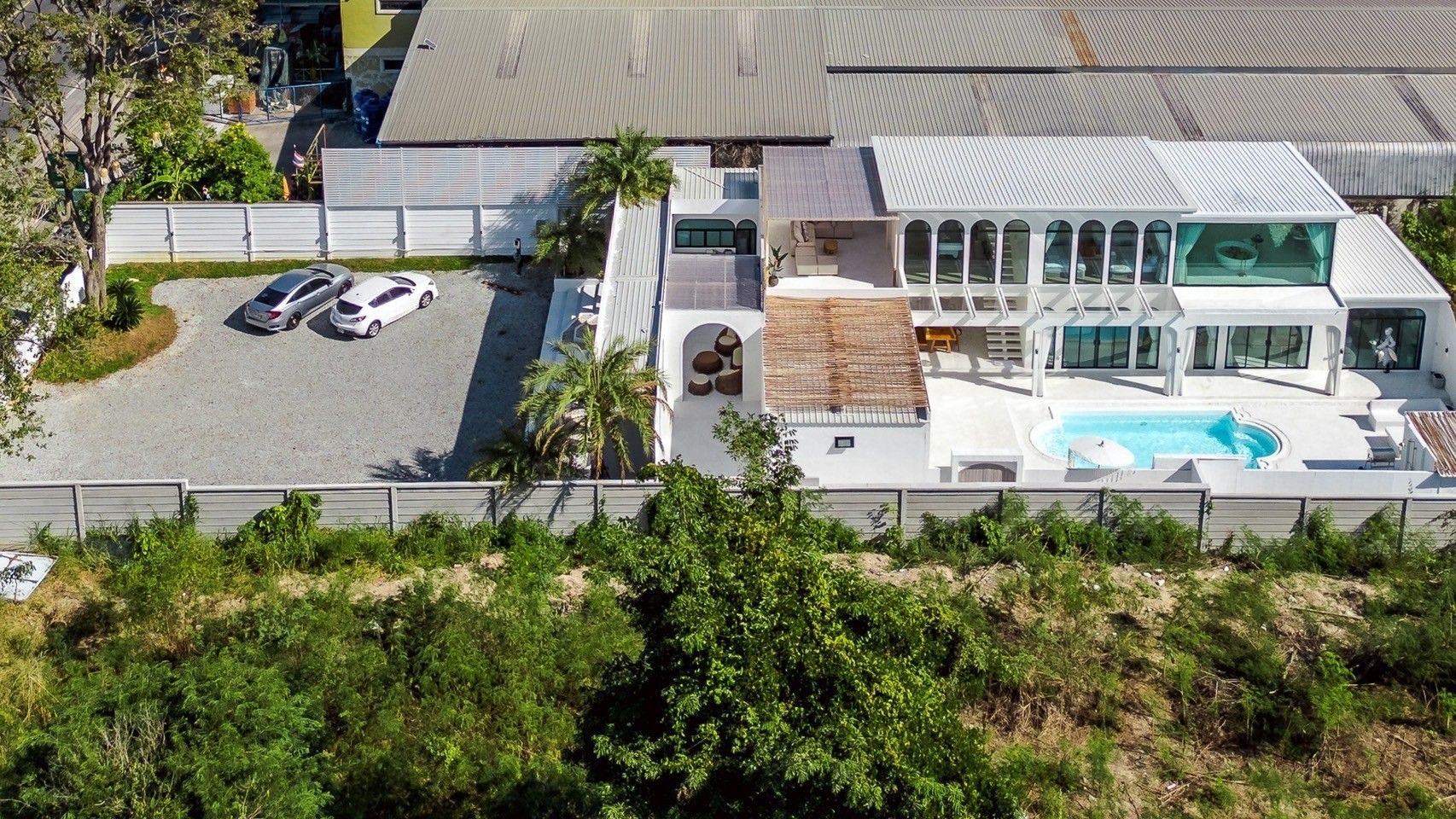 Aerial view of White Coco V Pool Villa, พัทยากลาง-นาเกลือ. Modern white villa with pool, parking, and outdoor spaces.