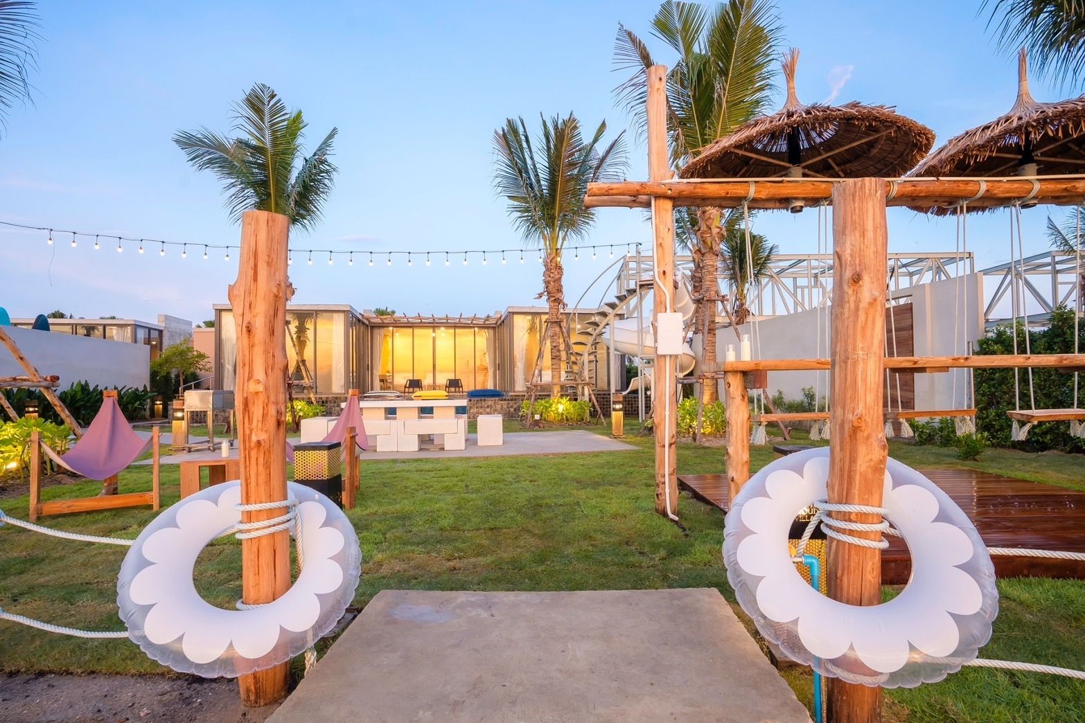 Amore' A Pool Villa garden entrance in หาดปึกเตียน-ชะอำ, Thailand, decorated with lifebuoys and string lights.