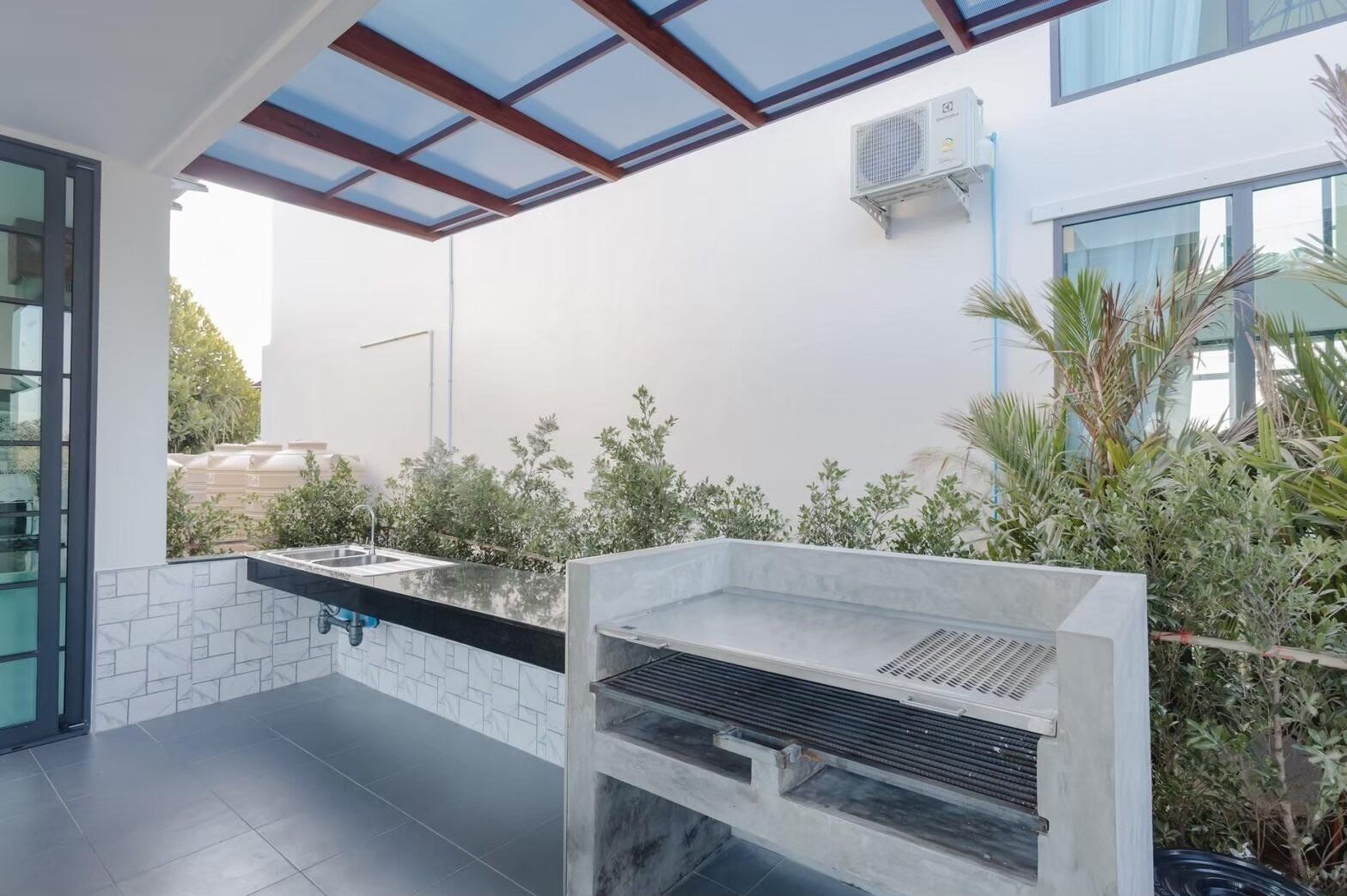Outdoor BBQ kitchen with grill, sink, and counter space at Exclusive Proud VII Villa in Hua Hin, perfect for al fresco...