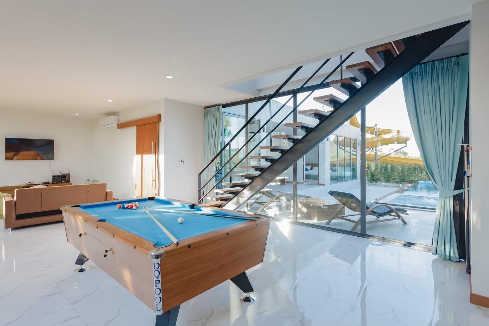 Indoor entertainment area with a blue billiards pool table and a brown sofa at Exclusive Proud VII Villa, Hua Hin.