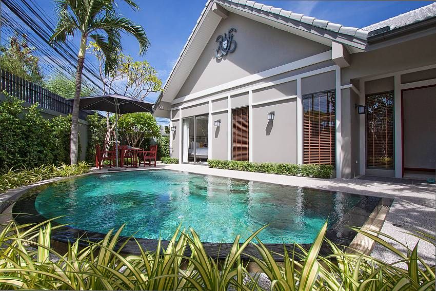 Private curved pool at Haven Pool Villa III, ทัพพระยา พัทยาใต้. Outdoor dining table and chairs under umbrella.
