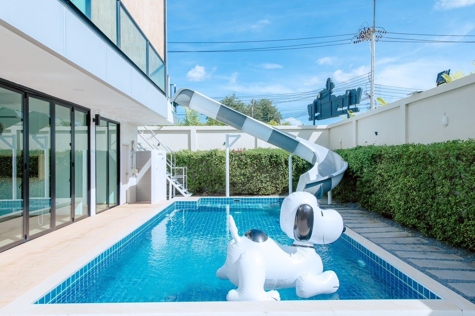 Private pool with waterslide and Snoopy float at Pool Lay AI Pool Villa, Na Jomtien, Pattaya, Thailand.