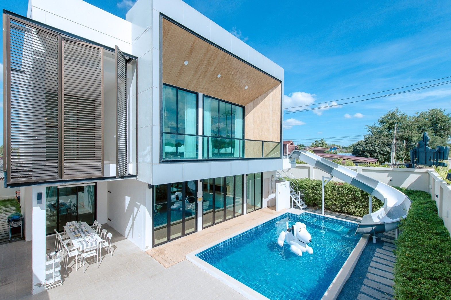 Pool with waterslide at Pool Lay AI Pool Villa in Na Jomtien, Pattaya. Modern villa with outdoor dining.
