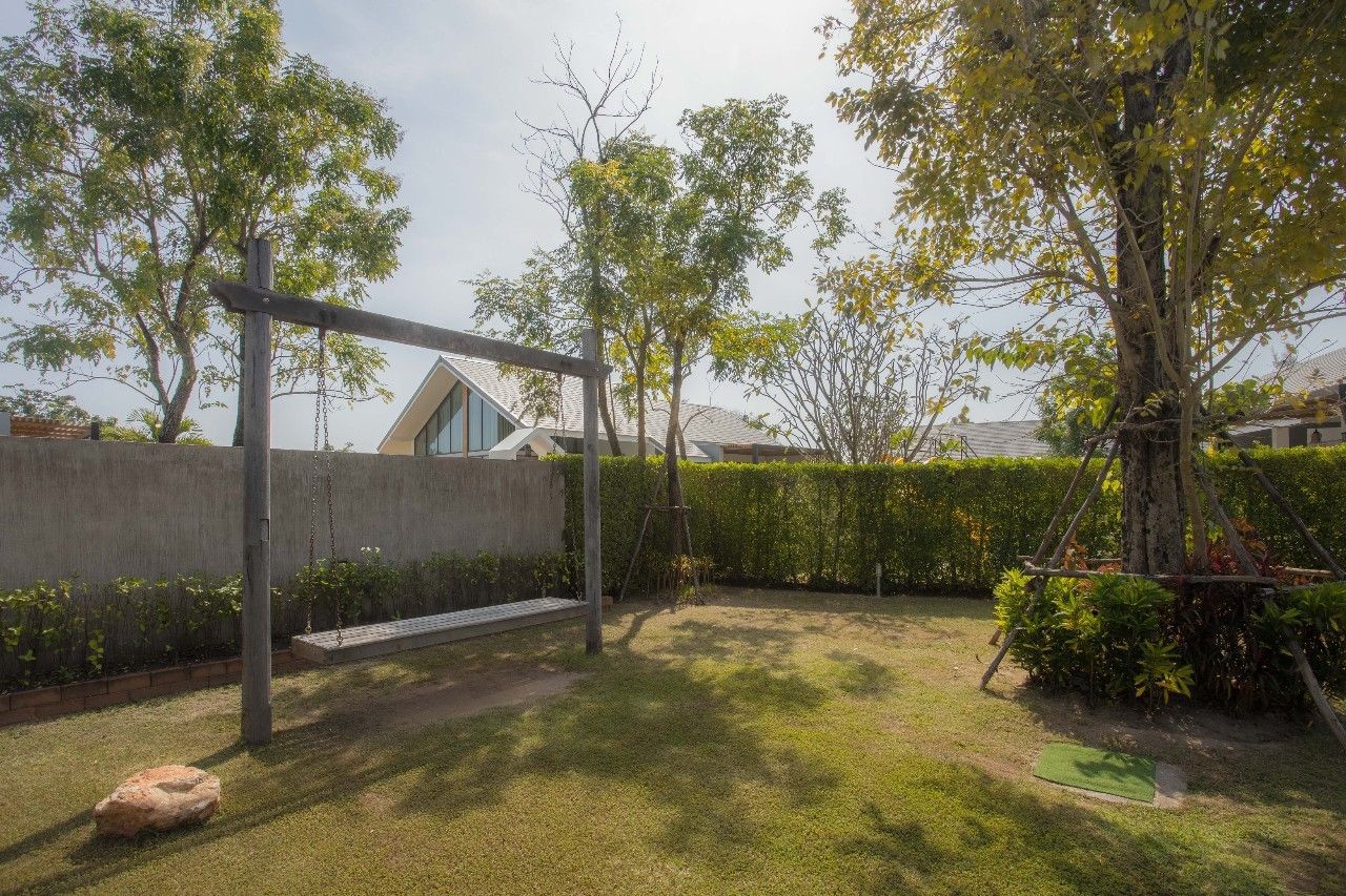 Lush garden with swing set at Proud V Pool Villa, Hua Hin. Relax in nature at this luxury Thailand rental.