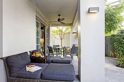 Relax on the covered patio at Sala Haven Nine Pool Villa, South Pattaya. Comfortable seating and outdoor dining.