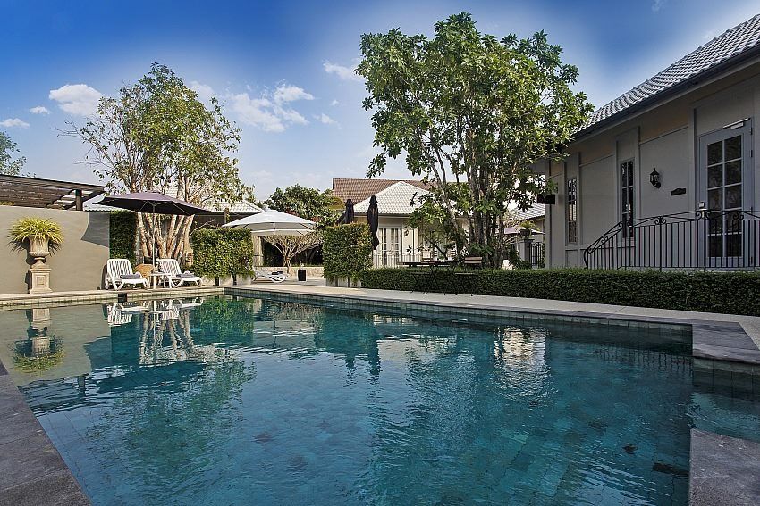 Sparkling pool and lounge chairs at Sala Haven Nine Pool Villa, South Pattaya. Relax in luxury by the pool.