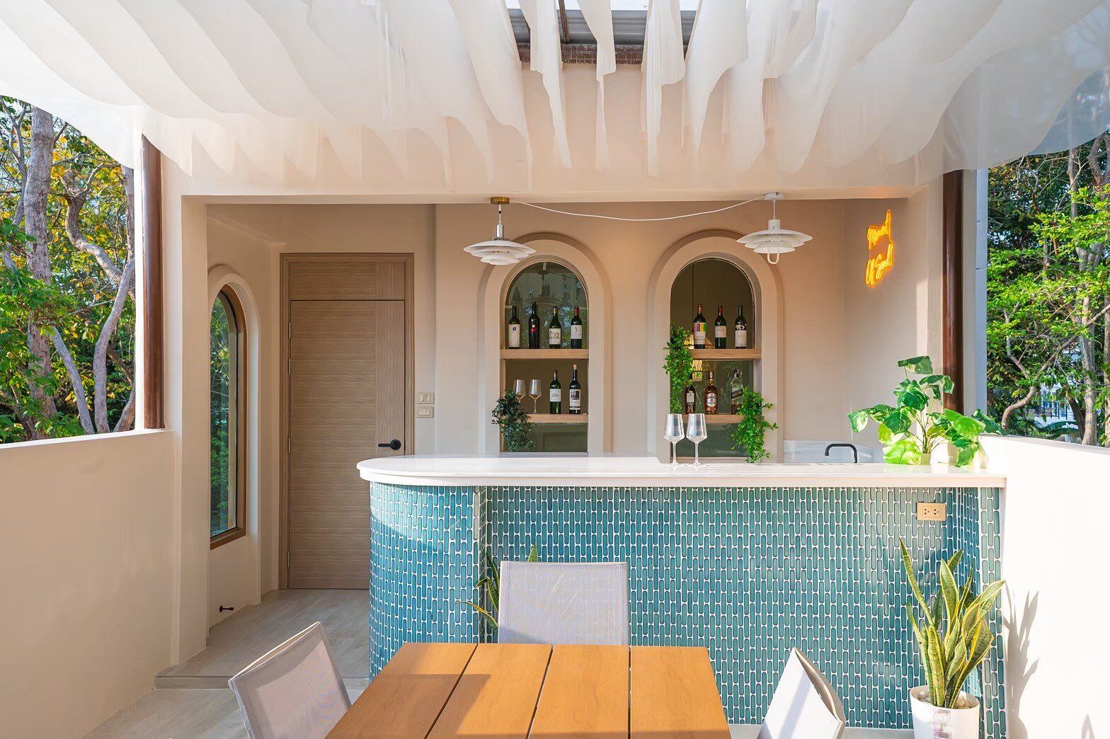 Outdoor bar and lounge area with blue mosaic tiles and wine display at Sand Moment VI Pool Villa, Rayong.