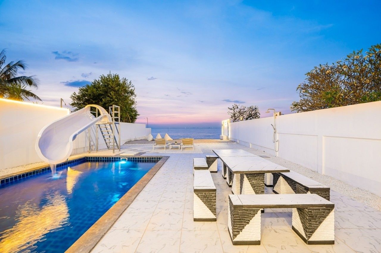 Sea View IV pool villa in Pattaya. Private pool with water slide and outdoor dining table overlooking the ocean.