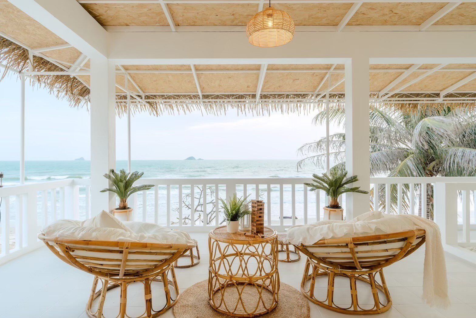 Relaxing rattan chairs on a beachfront balcony at Story II Pool Villa Hua-Hin, offering stunning ocean views.