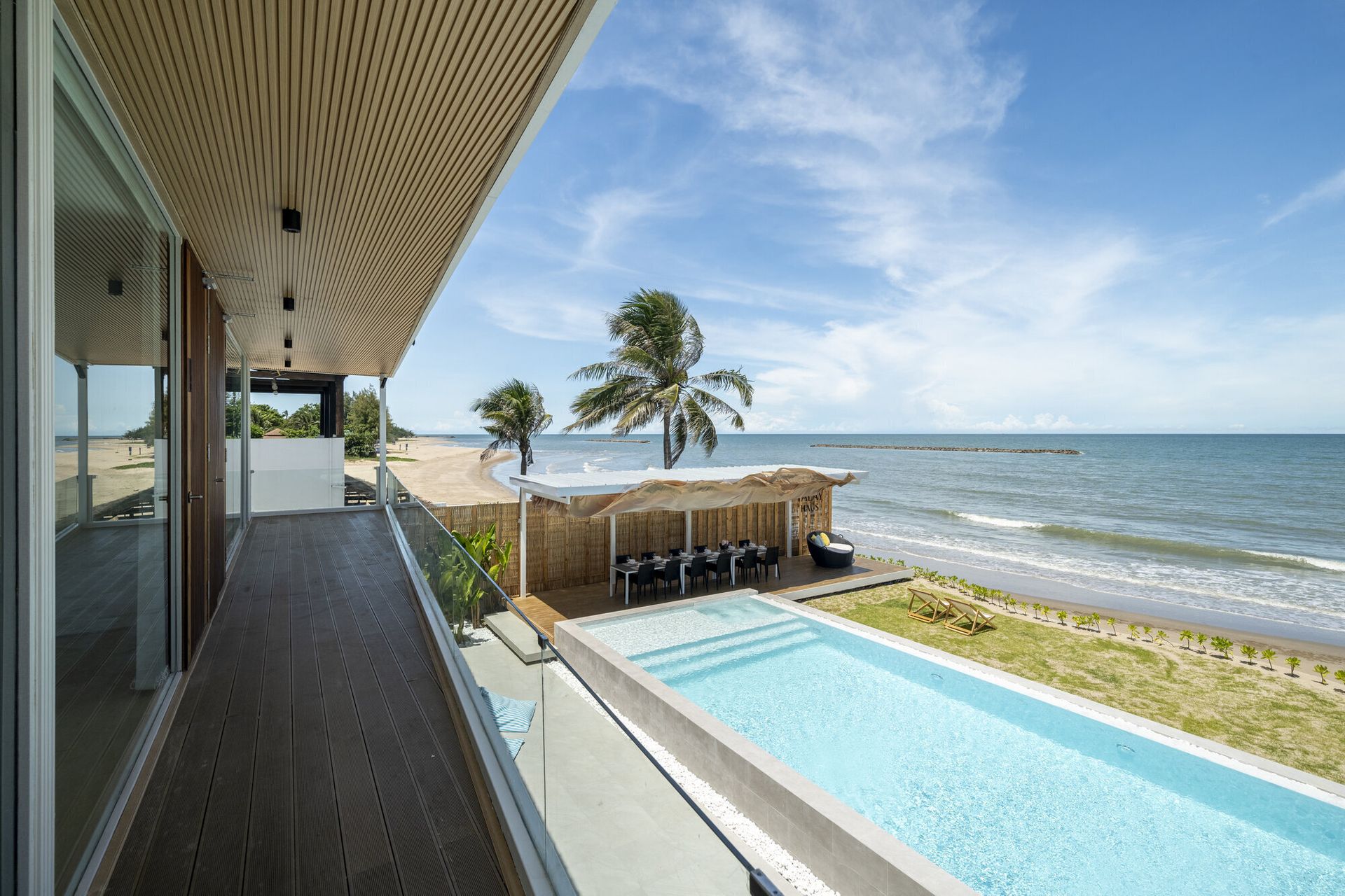 Stunning oceanfront infinity pool at Talay Haus X Pool Villa in Cha-Am, with a private balcony overlooking the beach.