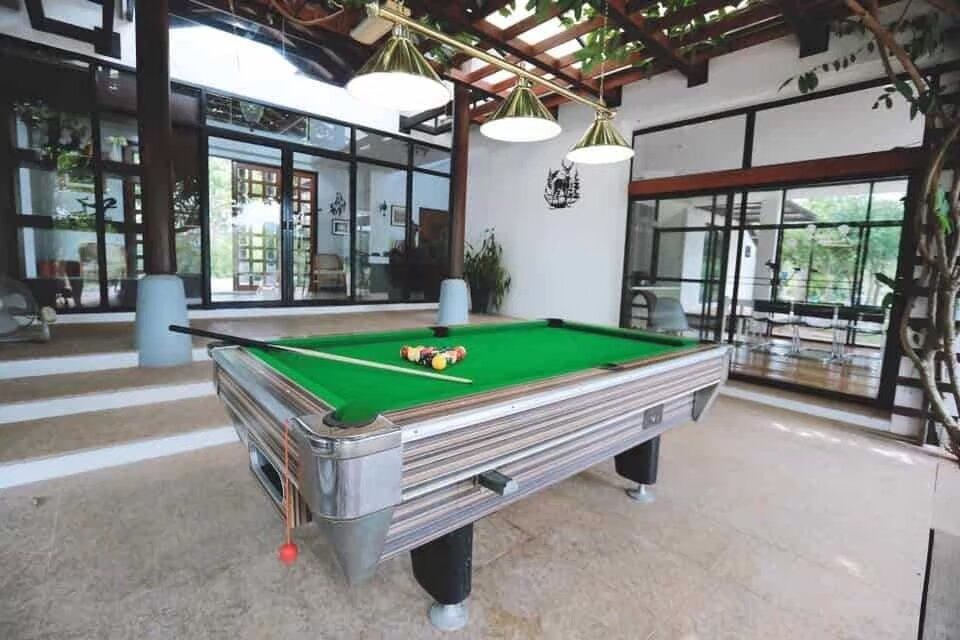 An outdoor billiards table with cues and balls at The Valley Khaoyai I, a luxury pool villa in Khao Yai, Thailand.