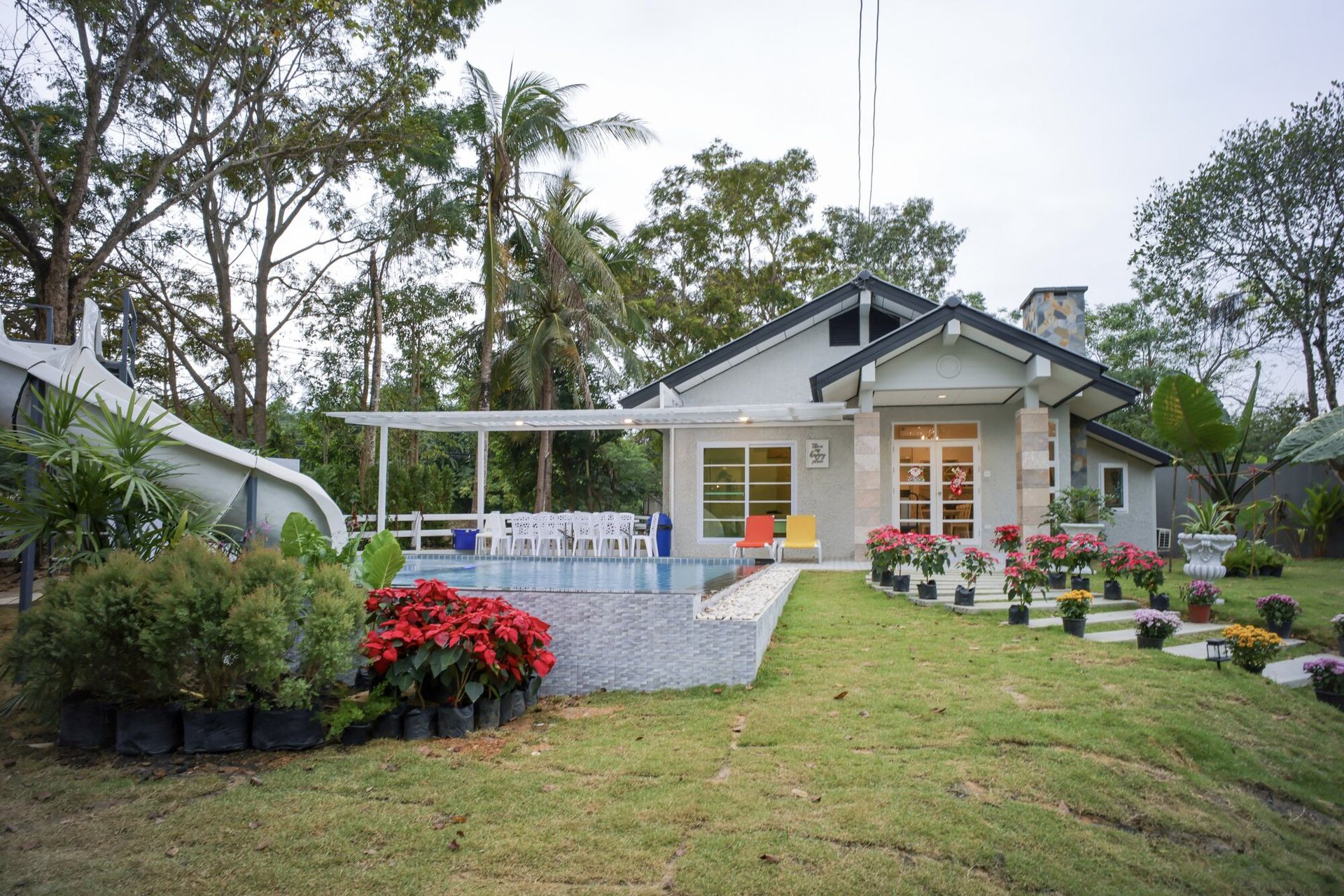 The Valley Khaoyai IX Villa's charming exterior with a private pool, water slide, and lush garden in Khao Yai, Thailand.