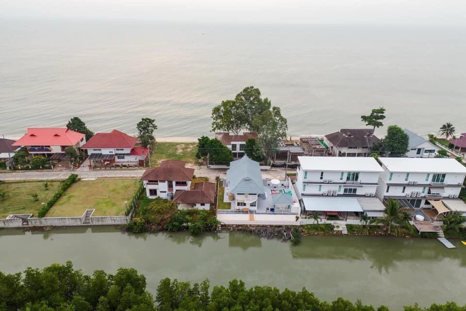 Aerial view of View Lay IV Pool Villa in Cha-Am, Thailand, showing its beachfront location and adjacent canal.