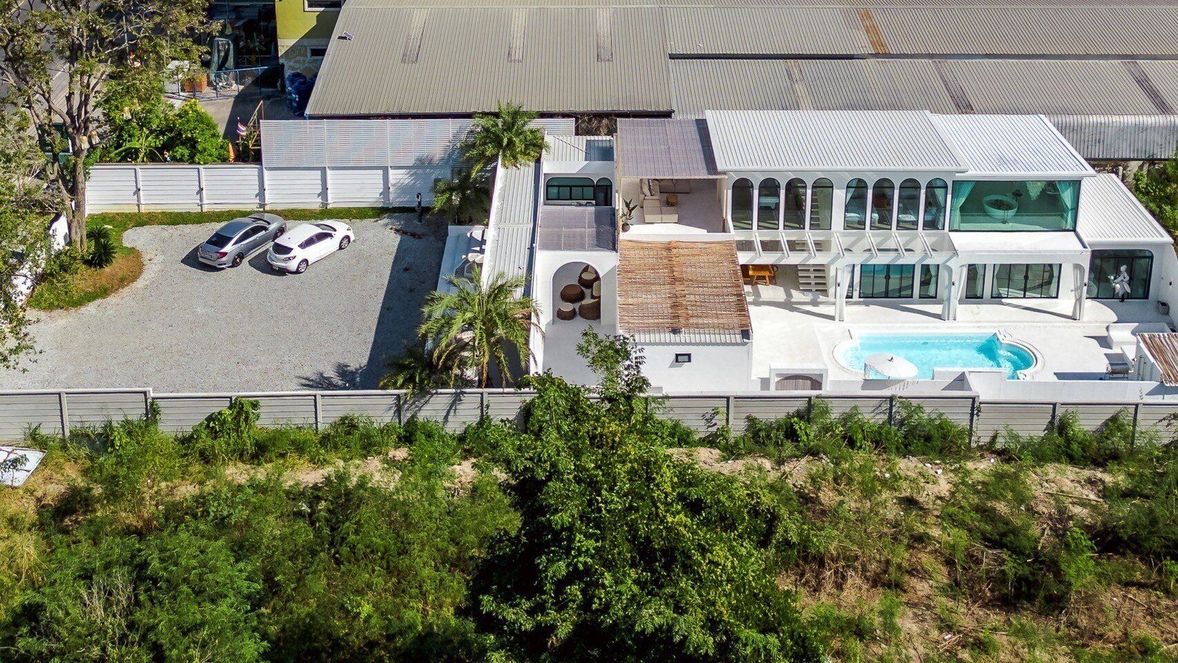 Aerial view of White Coco V Pool Villa, พัทยากลาง-นาเกลือ. Modern white villa with pool, parking, and outdoor spaces.