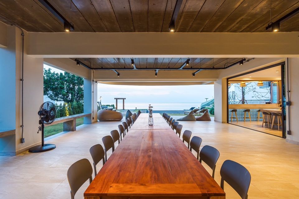 All About VII Pool Villa dining area with long wooden table and ocean view, near Bangket Beach, Cha Am.