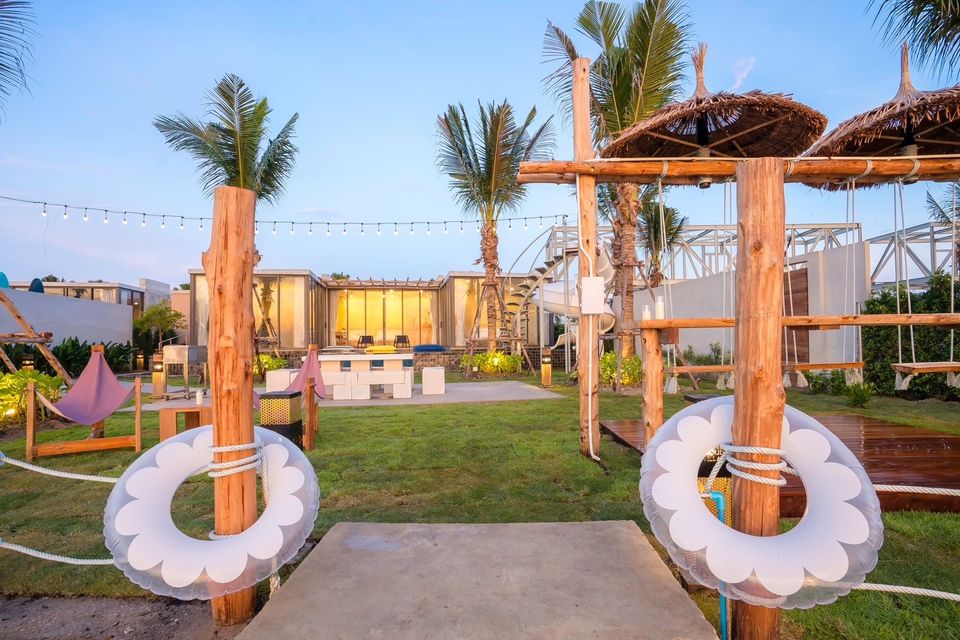 Amore' A Pool Villa garden entrance in หาดปึกเตียน-ชะอำ, Thailand, decorated with lifebuoys and string lights.