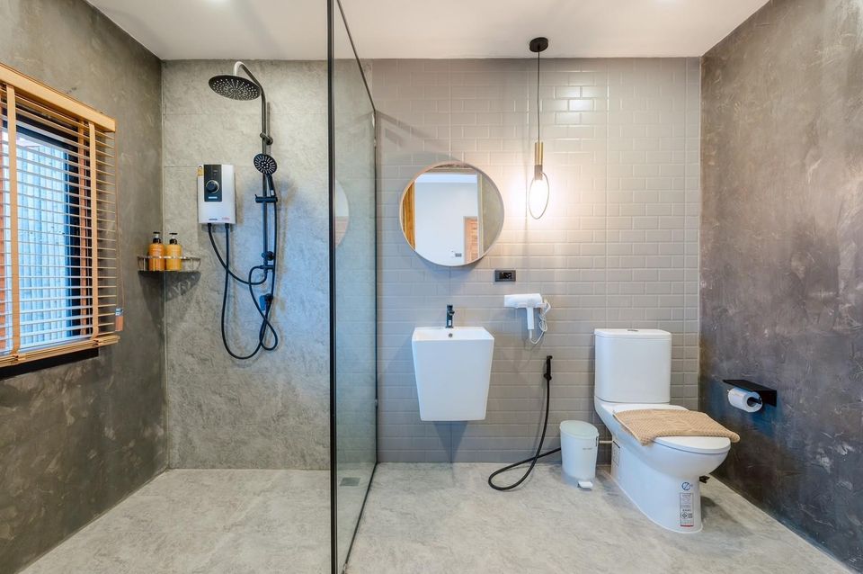 Modern bathroom with walk-in shower, toilet, and sink at Beach Blanca IV Pool Villa in Cha-Am, Thailand.