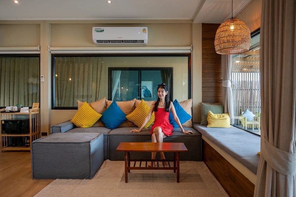 Modern villa lounge with grey sectional sofa, coastal decor and window seat — Beach Blanca IV Pool Villa