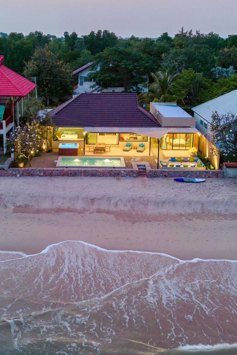 Aerial view of beachfront villa pool, hot tub and patio with warm lights at dusk — Beach Blanca IV Pool Villa
