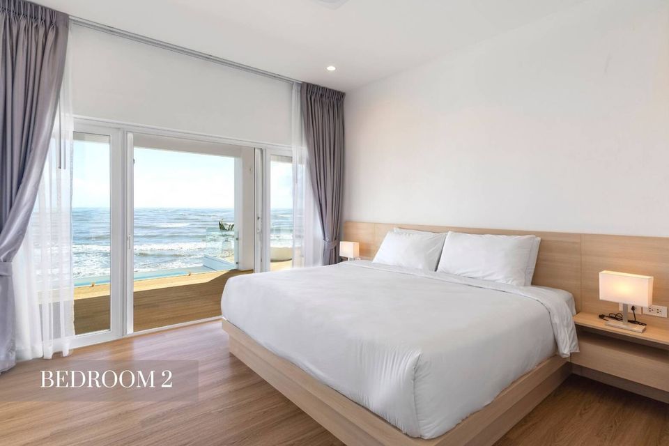 Bedroom 2 at Caribbean V Pool Villa, Hua Hin, features a comfortable king-size bed and stunning ocean views from the balcony.