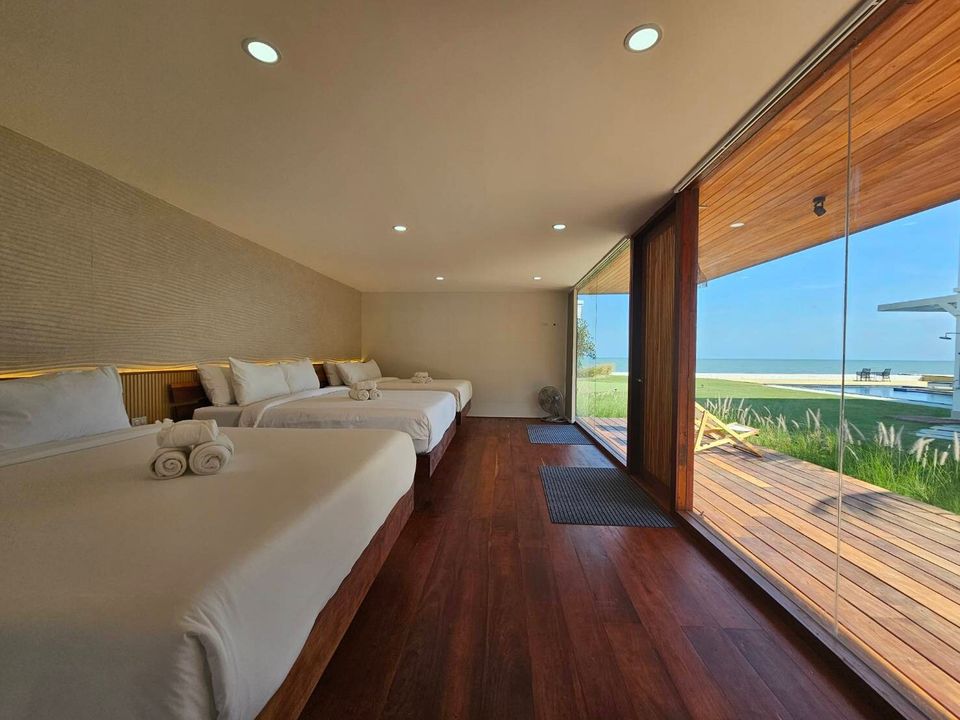 Spacious bedroom with three queen beds and ocean views at Caribbean V Pool Villa, Hua Hin. Perfect for families.