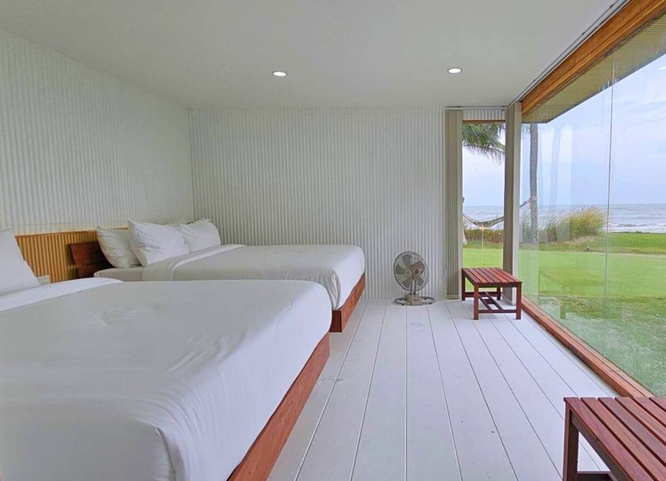 Bright bedroom with two twin beds and floor-to-ceiling windows offering direct seaview at Caribbean V Pool Villa, Hua Hin.