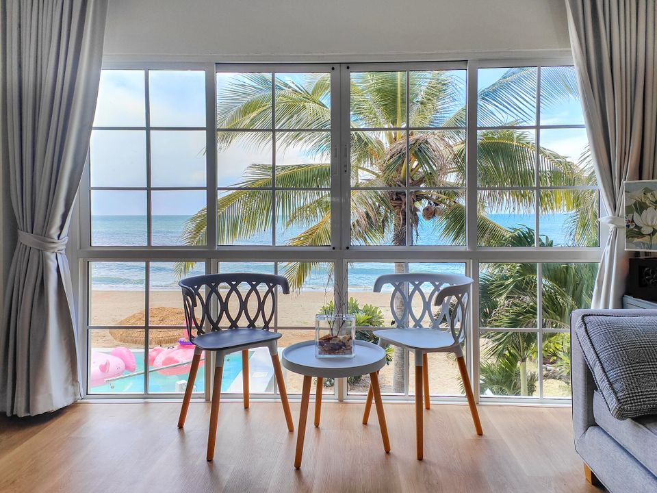 Cozy seating area with two chairs and a table, offering stunning beachfront views from Coastal Calm IV Pool Villa, Cha-Am.