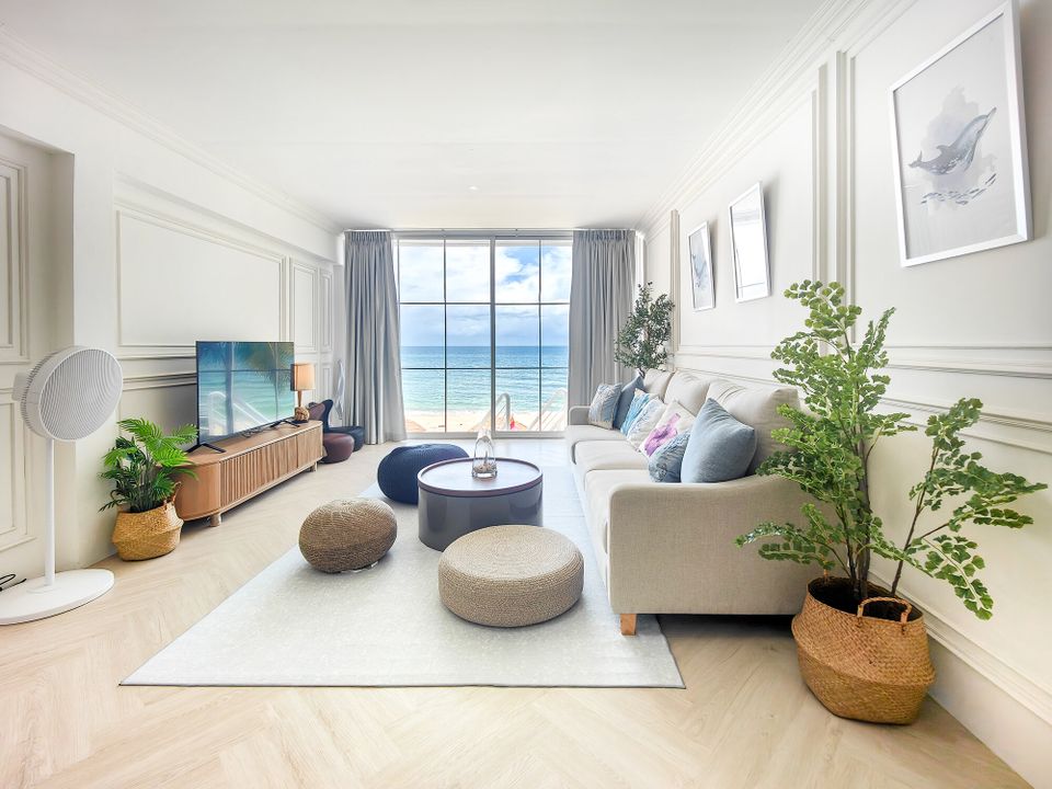 Bright living room at Coastal Calm IV Pool Villa, Cha-Am, with a comfortable sofa, TV, and stunning ocean views.