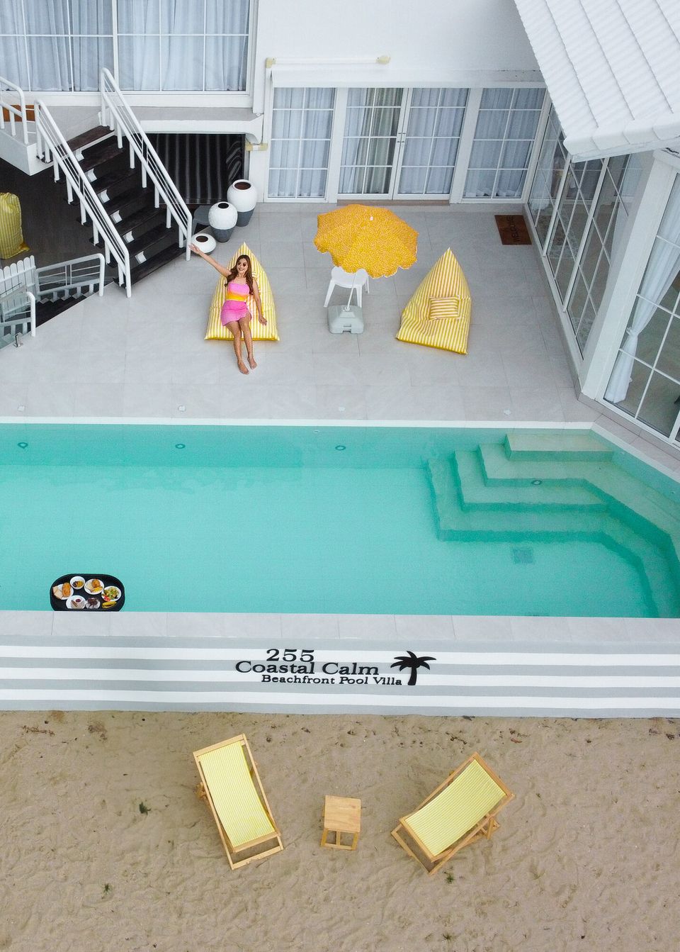 Aerial view of Coastal Calm IV Pool Villa in Cha-Am, showing the pool, beachfront, and white modern architecture.
