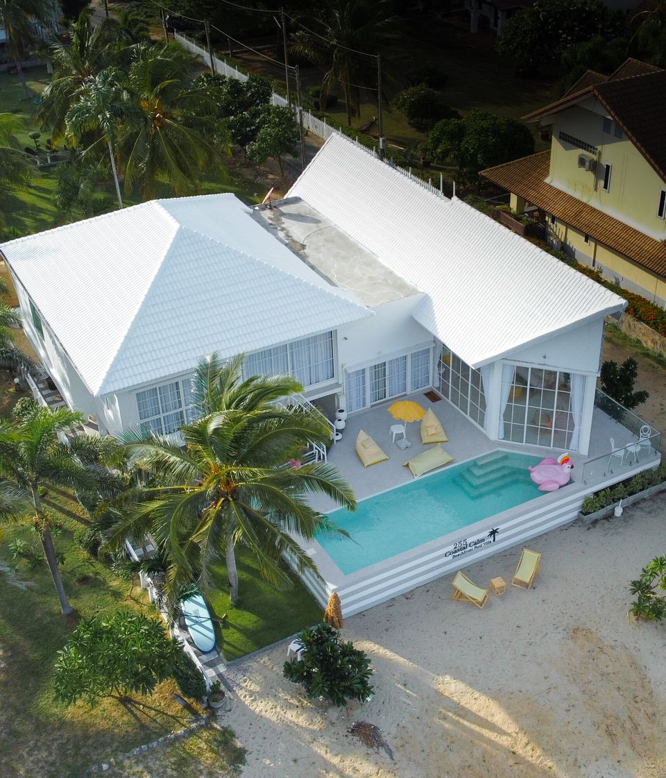 Aerial view of Coastal Calm IV Pool Villa in Cha-Am, showing the white modern exterior, private pool, and sandy beachfront.