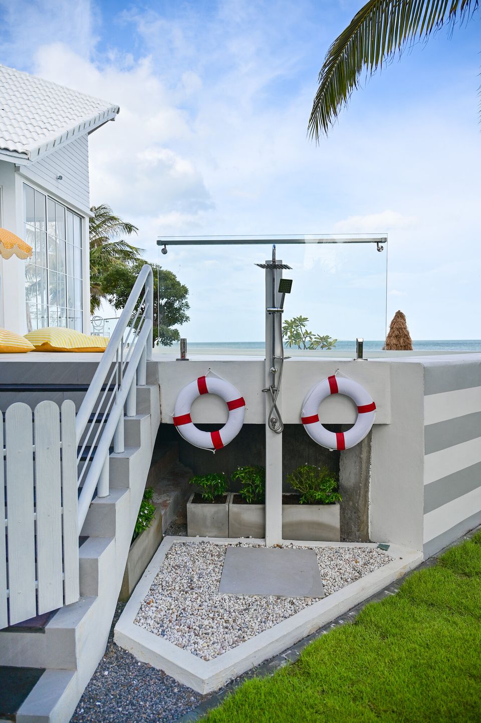 Outdoor rain shower and two lifebuoys by the pool deck at Coastal Calm IV Pool Villa, Cha-Am, with ocean views.