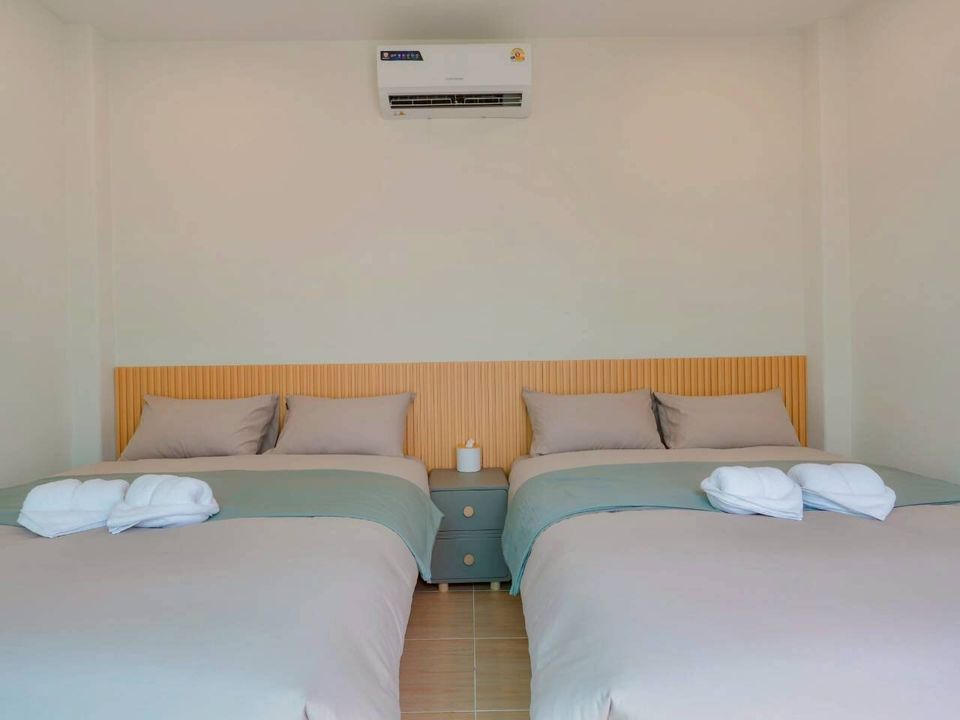 Bright bedroom at Darlington IV Pool Villa, Cha-Am, featuring two comfortable twin beds with fresh linens and air conditioning.