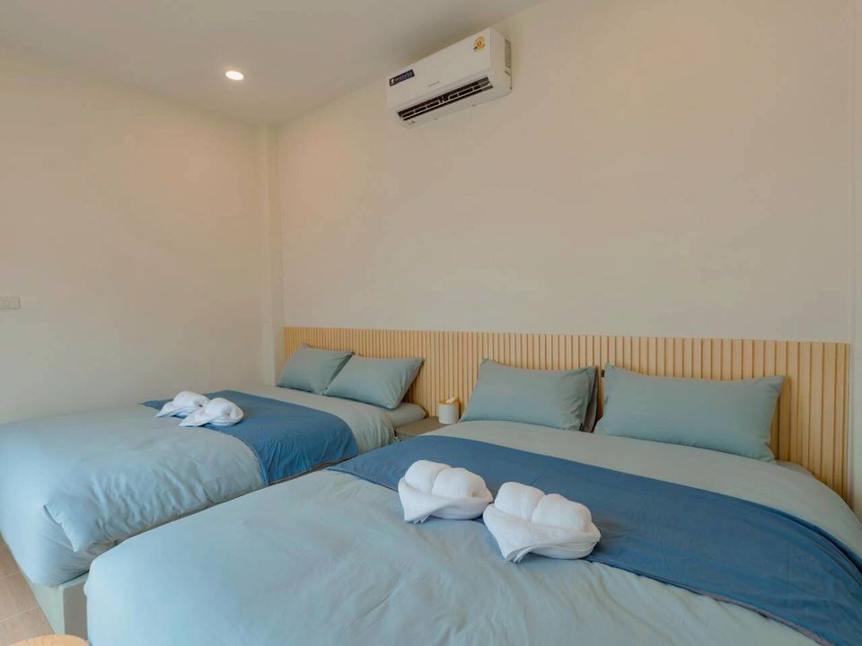 Two comfortable twin beds with blue bedding and white towels in a bedroom at Darlington IV Pool Villa, Cha-Am.