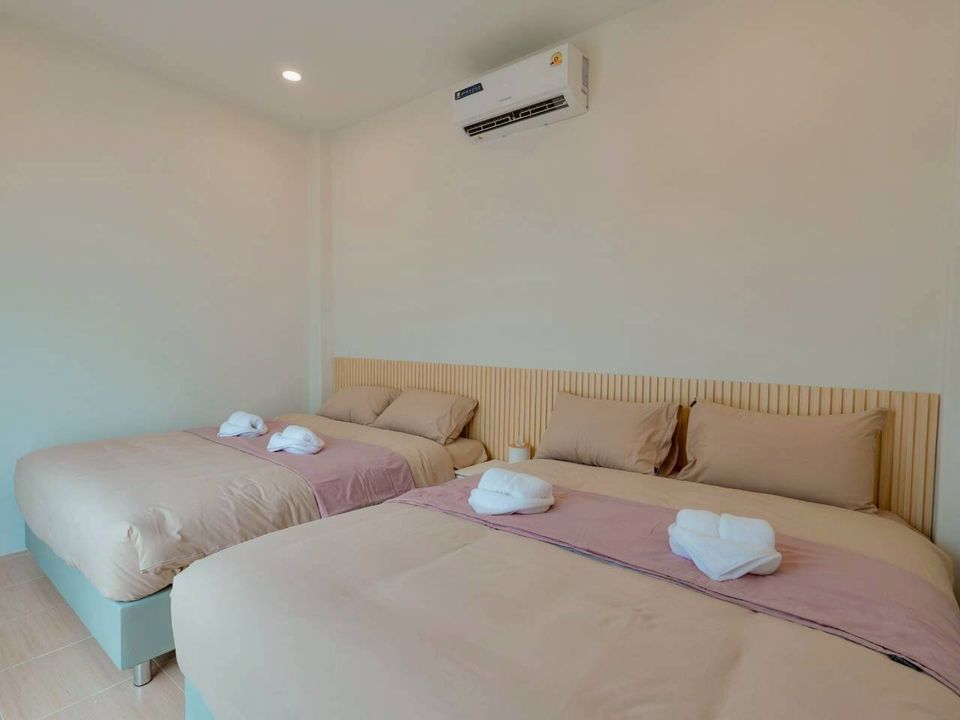 Two comfortable twin beds with neutral bedding and pink accents in a bedroom at Darlington IV Pool Villa, Cha-Am.