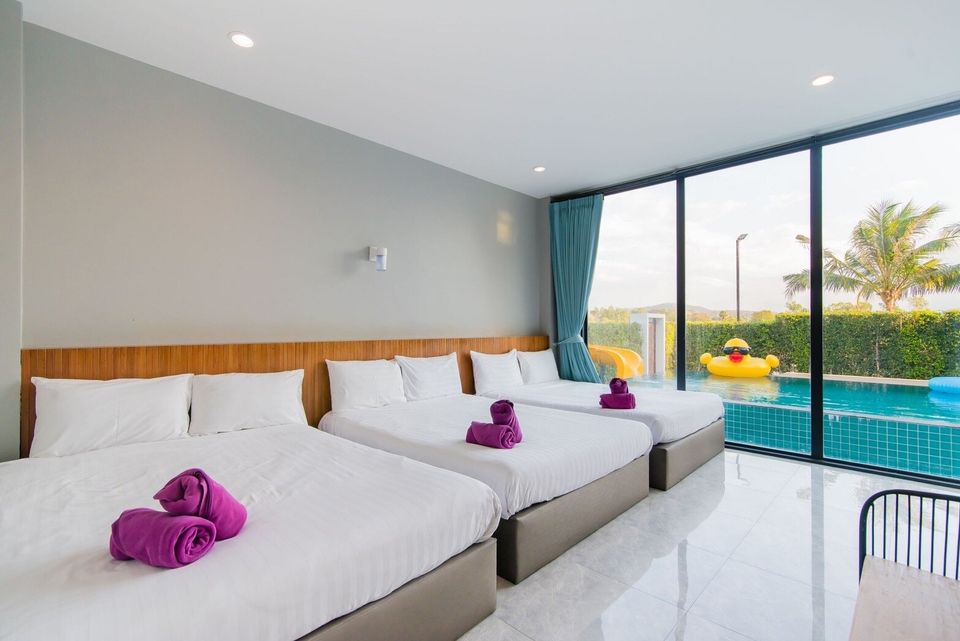 Bedroom with three beds and pool view at Exclusive Proud VII Villa in Hua Hin