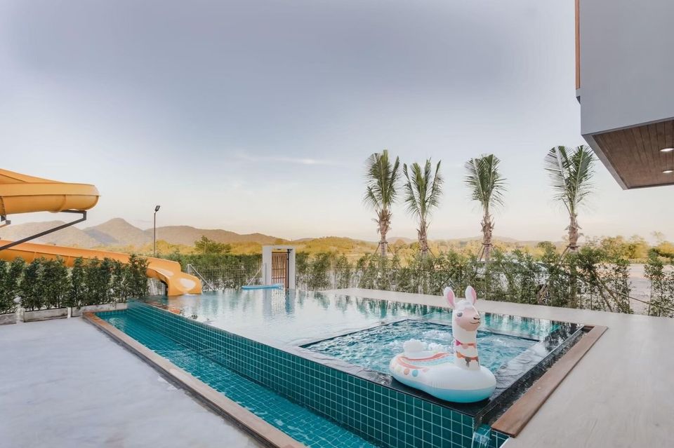 Exclusive Proud VII Villa in Hua Hin features a private pool with a fun water slide, jacuzzi, and a llama float.