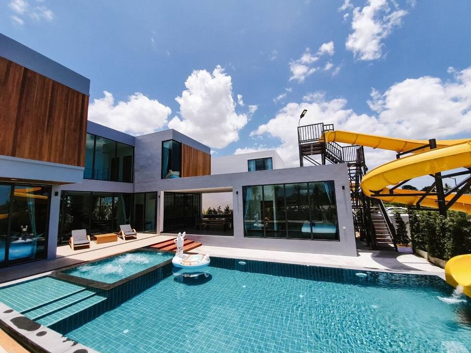 Exclusive Proud VII Villa in Hua Hin features a large swimming pool with a fun yellow water slide and bubbling jacuzzi.