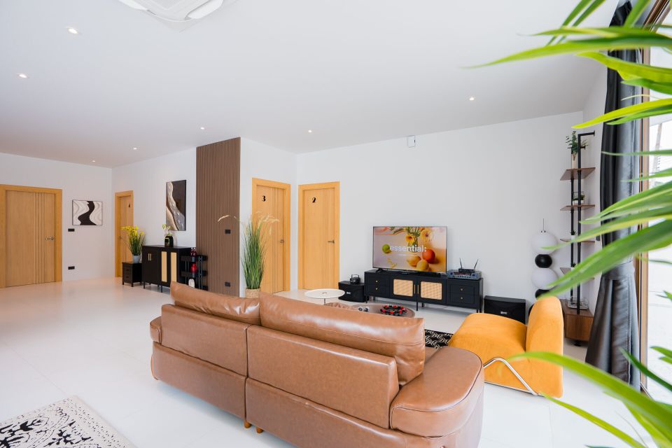 Living room at Good Day V Pool Villa, South Pattaya. Leather sectional sofa and TV with entertainment system.